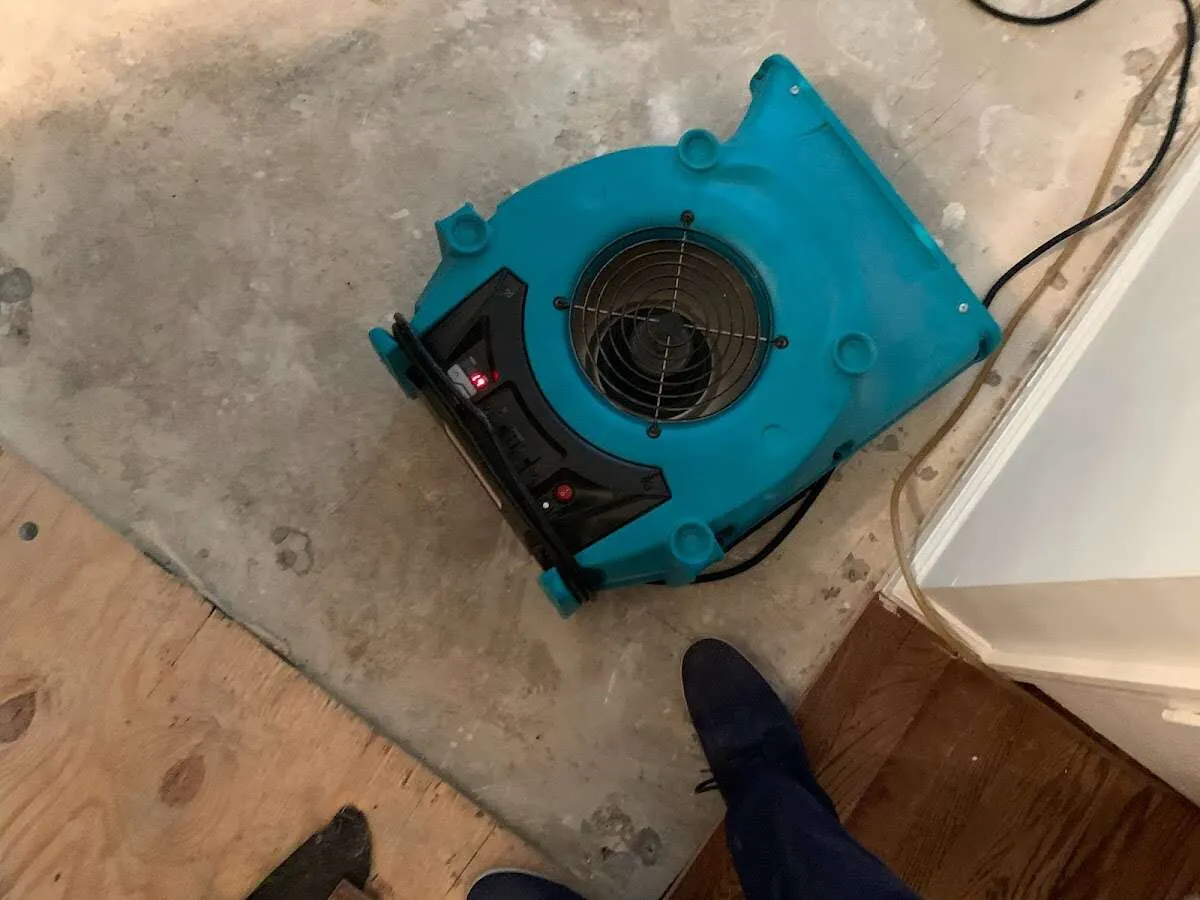 Air mover drying subfloor during Commercial Water Damage Restoration in Allouez